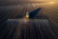 Tractor spraying soil in field