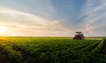 Tractor spraying soybean field