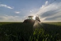 Tractor spraying wheat in field