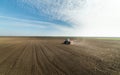 Tractor spreading artificial fertilizers in field