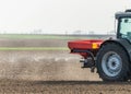 Tractor spreading artificial fertilizers in field Royalty Free Stock Photo