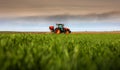 Tractor spreading artificial fertilizers in field Royalty Free Stock Photo