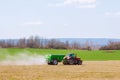 Tractor spreading fertilizer on grass field. Agricultural work