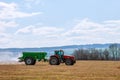 Tractor spreading fertilizer on grass field. Agricultural work