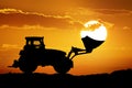 Tractor and sun into shovel bucket. Royalty Free Stock Photo