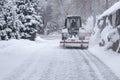 Tractor is sweeping snow in snowfall