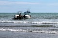 Tractor tows a small boat back onto land at Otaki Beach, Kapiti Coast, New Zealand