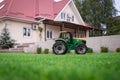 Tractor toy with blurry grass and a house on the background. Copyspace Royalty Free Stock Photo