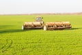 A tractor with trailed agricultural machinery working on the field.