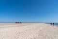 Tractor trailer bringing tourists to the northern tip of Denmark parked on the beach under a blue sky