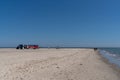 Tractor trailer bringing tourists to the northern tip of Denmark parked on the beach under a blue sky