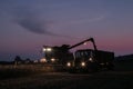 Tractor and trailer with headlights on at night time