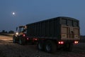 Tractor and trailer with headlights on at night time