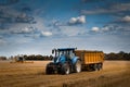 Tractor and trailer leading cereal out of a Barley field. Royalty Free Stock Photo