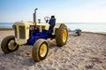 Tractor with trailer for transport boats on the sandy beach Royalty Free Stock Photo