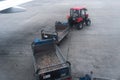 A tractor with a trailer for transporting passenger luggage between an airplane and an airport terminal. Baggage transportation