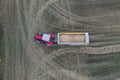 A tractor transports the ripe golden wheat to the grain field harvested by the combine. Agricultural work in summer. Drone