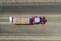 A tractor transports the ripe golden wheat to the grain field harvested by the combine. Agricultural work in summer. Drone