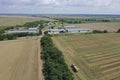 A tractor transports the ripe golden wheat to the grain field harvested by the combine. Agricultural work in summer. Drone