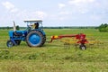 A tractor turning cut hay Royalty Free Stock Photo