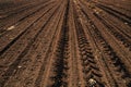 Tractor tyre tracks in plowed field soil