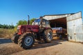 Tractor unloading grain harvest to granary storage on farm