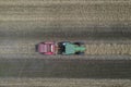 A tractor uses a trailed bale machine to collect straw in the field and make round large bales. Agricultural work, baling, baler,