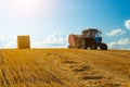 A tractor uses trailed bale machine to collect straw in the field and make round large bales. Agricultural work, baling Royalty Free Stock Photo