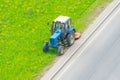 Tractor uses trailed lawn mower to mow grass on city lawns, aerial view Royalty Free Stock Photo