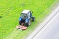 Tractor uses trailed lawn mower to mow grass on city lawns, aerial view Royalty Free Stock Photo