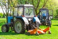 Tractor uses trailed lawn mower to mow grass on city lawns Royalty Free Stock Photo