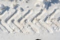 Tractor wheel imprint on white snow, transport trail