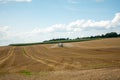 Tractor on which a trailer filled with liquid manure hangs drives over a field and sprays the liquid slurry