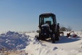 Tractor in winter in the snow,in winter an old tractor stands on a farm in the yard Royalty Free Stock Photo
