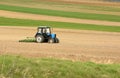 Tractor at work cultivating a field in spring, farmland, plowed