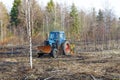 Tractor work the land among the trees Royalty Free Stock Photo
