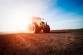 Tractor working on farm land on sunset Royalty Free Stock Photo