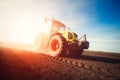 Tractor working on farm land on sunset Royalty Free Stock Photo