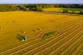 Tractor working in the field with hay to get it dried under the heat of the summer sun. Agriculture field haystack. Landscape with