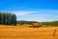 Tractor working in the field with hay to get it dried under the heat of the summer sun. Agriculture field haystack