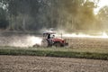 Tractor working in field opening preparing soil for planting rice.