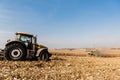 Tractors harvesting golden field against blue