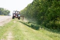 Tractors machines mowing lawn grass along road Royalty Free Stock Photo