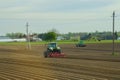 Tractors plow the field and prepare the soil for sowing.