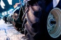 Tractors stand in a row on a winter street. View of rubber tires Royalty Free Stock Photo