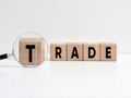Trade analysis concept. The word trade on wooden cubes with a magnifying glass Royalty Free Stock Photo
