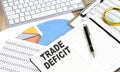 TRADE DEFICIT text on notebook with chart and keyboard Royalty Free Stock Photo