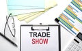 TRADE SHOW text on paper sheet with chart,color paper and calculator Royalty Free Stock Photo