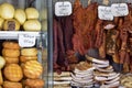 Trade in smoked meat and pork fat. Cheese heads of different colors and sizes are stacked on counter. Inscriptions in Romanian.