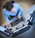 Trader Analyzing Data On Multiple Screens At Desk